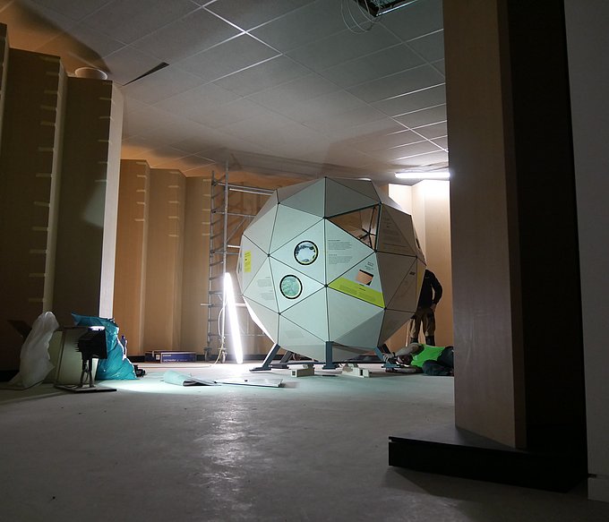 Das Raumschiff Erde, dargestellt durch eine hölzerne Kugel aus Dreiecken steht fast fertig aufgebaut in den Räumen des Energie-Bildungszentrums um:welt