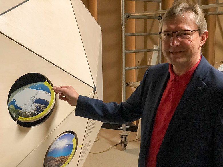 Ludwig Friedl, Geschäftsführer der Energieagentur Regensburg, erläutert die Funktionen des "Raumschiffs Erde", einer hölzernen Kugel aus Dreiecken in den Räumen des Energie-Bildungszentrums um:welt